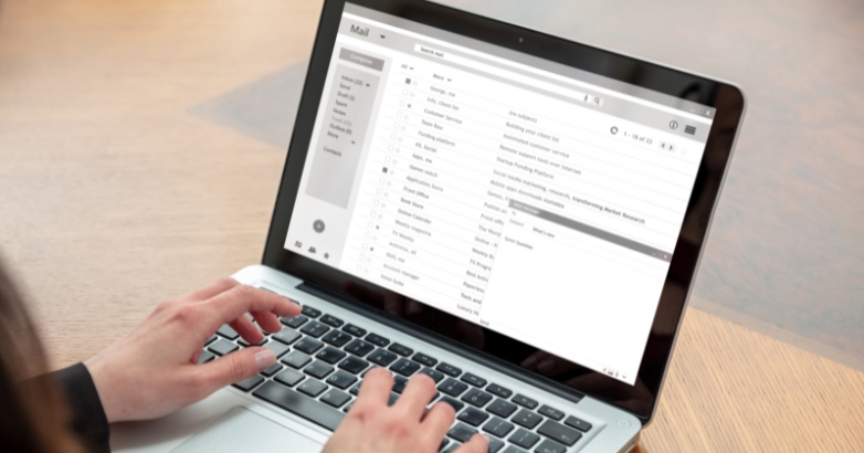 Individual using a laptop to compose an email regarding hotel marketing examples emphasizing personalization and segmentation.