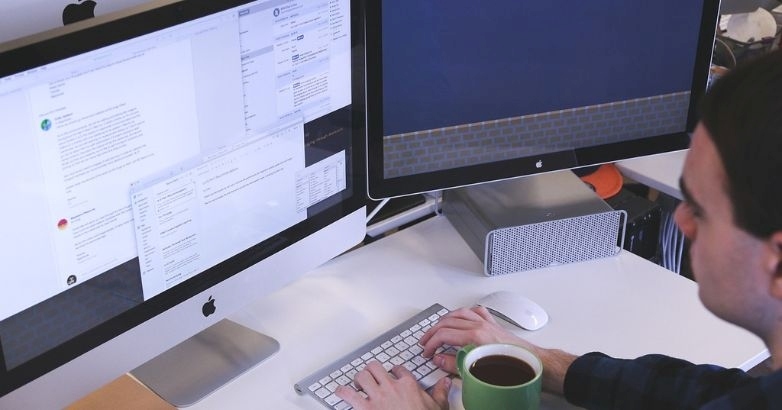 A man is seated at a desk engaged in hotel email marketing and automated email campaigns.