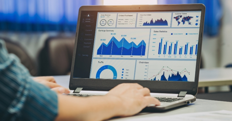 A person analyzes Facebook advertising analytics for hotels on a laptop displaying various graphs and data.