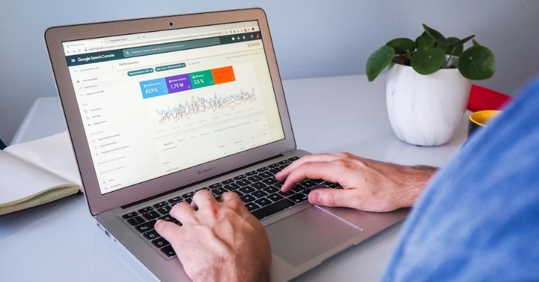 A person typing on a laptop, focused on SEO strategies for hotels and Google's ranking factors.