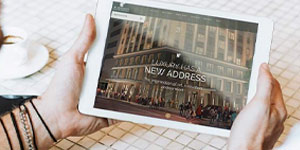 A person showcasing an iPad with the New York City skyline, highlighting digital marketing strategies for hotels.