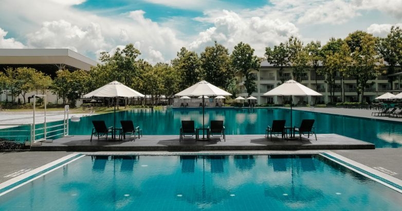 Spacious pool area featuring umbrellas and lounge chairs, perfect for guests to enjoy the sun and unwind.