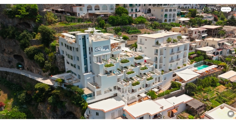 Aerial view of Casa Angelina hotel perched on a cliff, showcasing its elegant design and stunning coastal surroundings.
