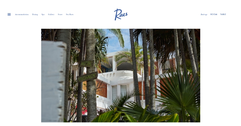 Website for Raes on Wategos, highlighting palm trees and a sleek white building in a sunny coastal environment.