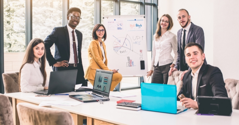 A group of business professionals discussing strategies around a table, focused on digital marketing for hotels.