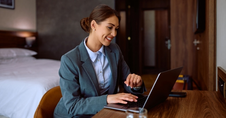Hotel manager using a laptop to coordinate internet marketing and guest engagement strategies.