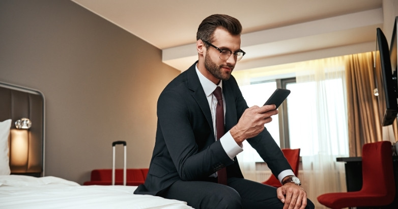 Hotel guest using a smartphone to research and book travel, showcasing the Internet Marketing for Hotels.