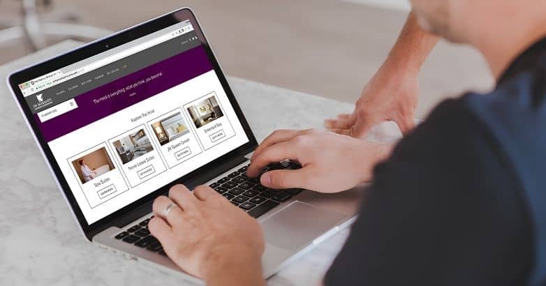 Guest browsing hotel room options on a laptop for a hotel website redesign