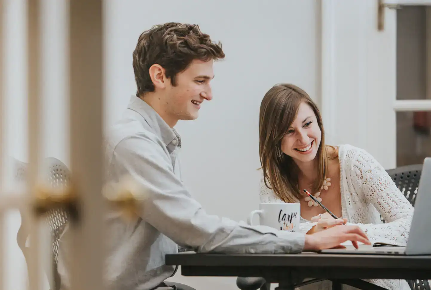 Two of Mediaboom's marketing professionals collaborating at a laptop