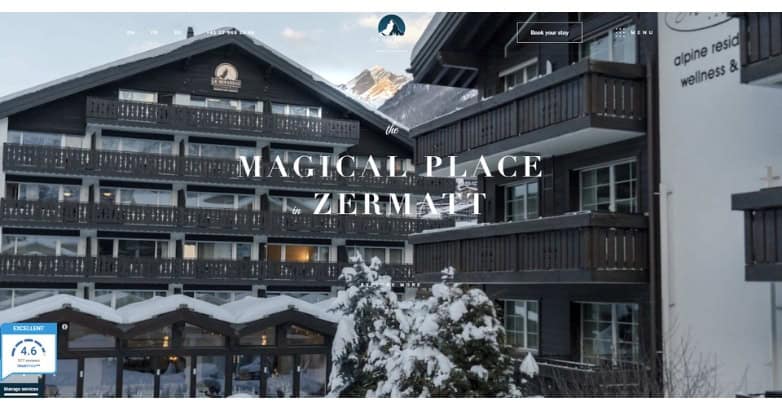 A snowy mountain resort in Zermatt featuring wooden architecture and balconies, with a welcoming entrance.