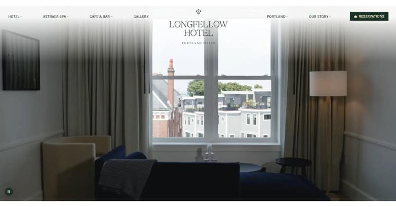 A cozy hotel room featuring a large window with a view, modern furnishings, and soft lighting.