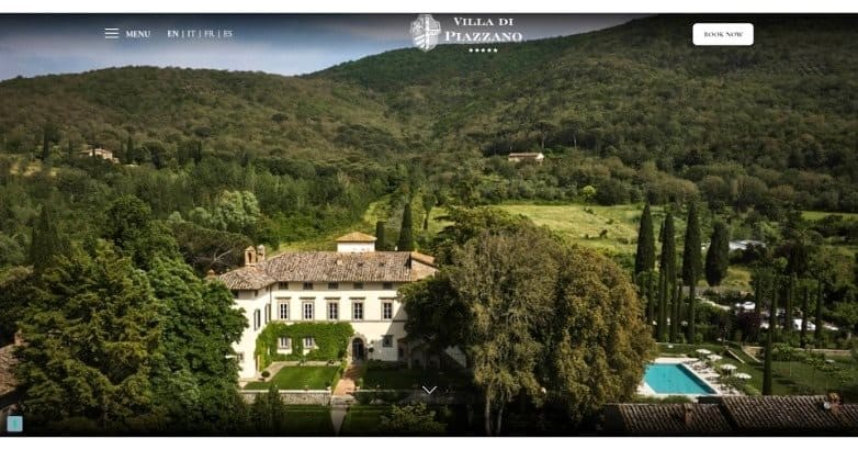 Aerial view of a villa surrounded by lush greenery and mountains, featuring a pool and landscaped gardens.