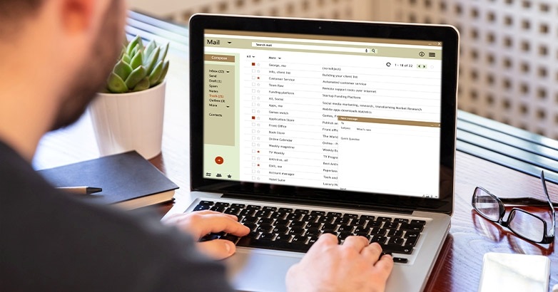 A man focused on a laptop screen showing an email related to hospitality email marketing and automation techniques.