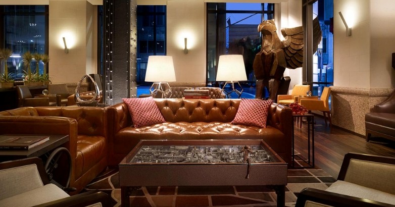 Stylish hotel lobby showcasing leather couches and a coffee table, inviting guests to relax in a sophisticated environment.