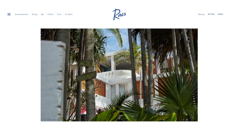 Website for Raes on Wategos, highlighting palm trees and a sleek white building in a sunny coastal environment.