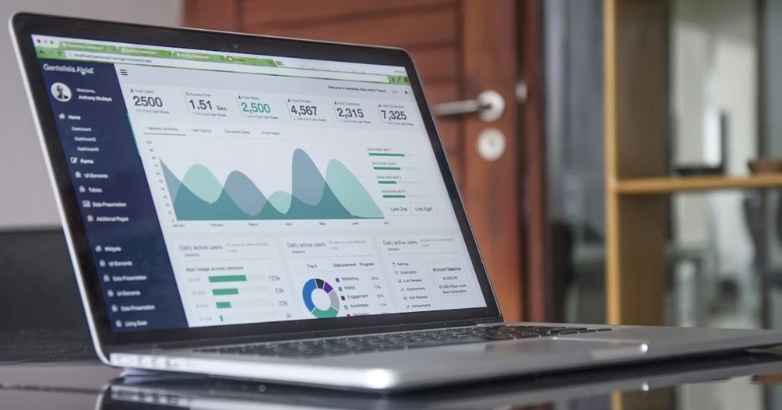 A laptop screen shows a graph related to hotel branding and success measurement.