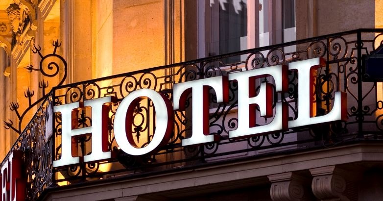 A brightly lit hotel sign at night, emphasizing brand awareness and reputation management in the hospitality industry.