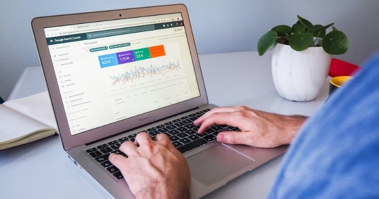 Person using a laptop to develop hotel ad campaigns, focusing on SEO and website optimization efforts.